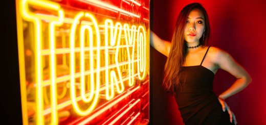 A stylish woman poses by a vibrant Tokyo neon sign, exuding modern urban nightlife.